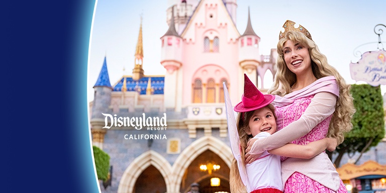 Kid dressed up as character hugging sleeping beauty in front of the castle